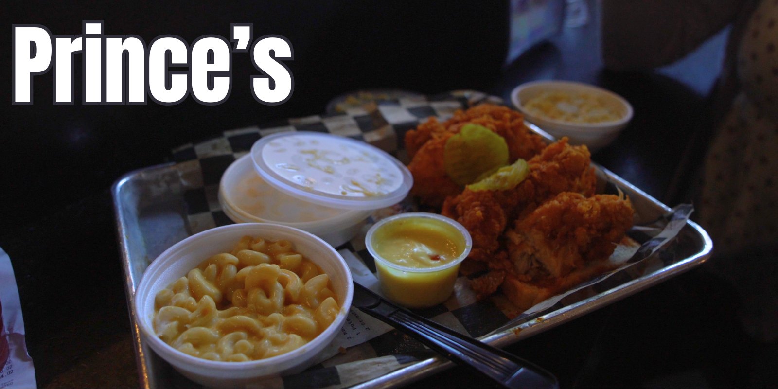 A tray of Prince's hot chicken with mac and cheese, coleslaw and pickles
